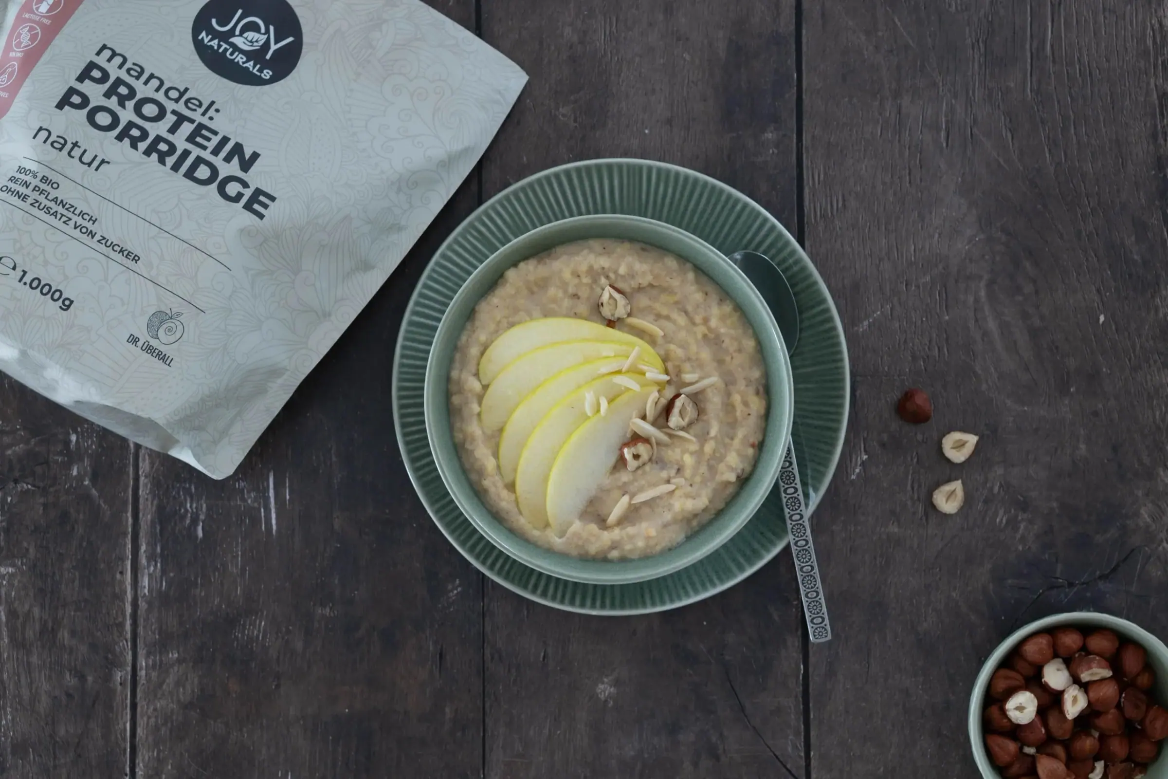 Protein-Porridge mit Apfelspalten neben der Produktverpackung