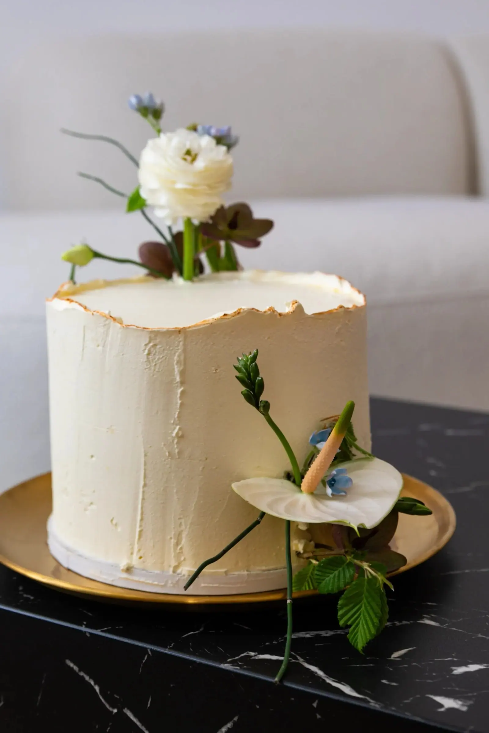 Weiße Hochzeitstorte mit Blüten und Goldrand